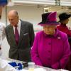 Elizabeth II visite l'usine de fabrication de Mars à Slough le 5 avril 2013 avec son époux le duc d'Edimbourg.