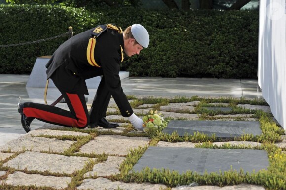 Le prince Harry s'incline et dépose des fleurs sur une tombe au cimetière national américain d'Arlington en Virginie, le 10 mai 2013 au cours de sa visite officielle aux Etats-Unis, où il s'est recueilli notamment sur la tombe du soldat inconnu et celle de John F. Kennedy.