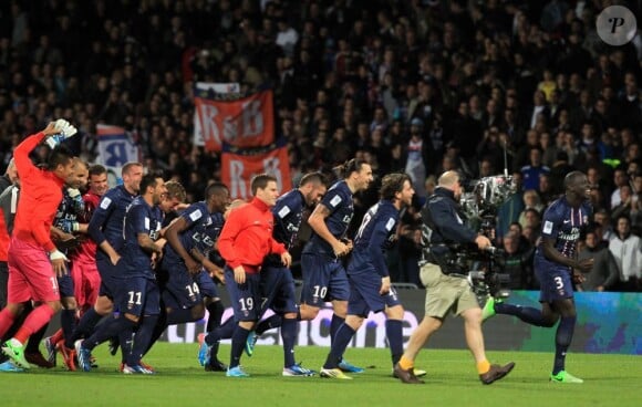 L'équipe du PSG se précipite vers la tribune où avaient pris place ses supporters pour célébrer son titre de champion de France acquis après sa victoire 1-0 sur la pelouse de l'Olympique Lyonnais, le 12 mai 2013 à Lyon