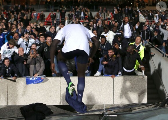 Mamadou Sakho se déshabille et partage ses affaires avec les supporters après la victoire du PSG qui lui offre le titre de champion de France sur la pelouse de l'Olympique Lyonnais, le 12 mai 2013 à Lyon