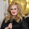 Adele prend la pose avec son Oscar de la meilleure chanson pour Skyfall, lors de la 85e cérémonie des Oscars à Hollywood, le 24 février 2013. La chanteuse va être faite membre de l'Ordre de l'Empire britannique.