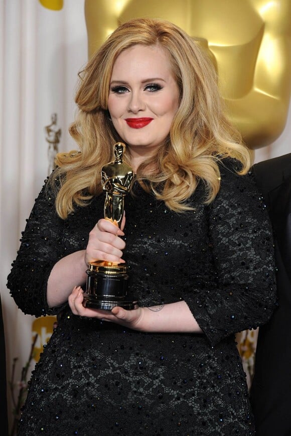 Adele prend la pose avec son Oscar de la meilleure chanson pour Skyfall, lors de la 85e cérémonie des Oscars à Hollywood, le 24 février 2013. La chanteuse va être faite membre de l'Ordre de l'Empire britannique.