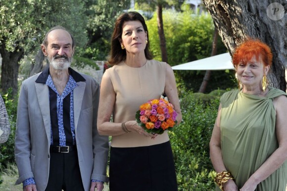 La Princesse Caroline de Hanovre pose avec le peintre russe Erik Boulatov et son épouse Natacha lors de la visite de l'exposition d'Erik Boulatov à la Villa Paloma à Monaco, le 24 juin 2013.