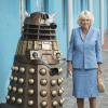 Le prince Charles et Camilla Parker Bowles visitent les studios de la série Doctor Who à Cardiff, le 3 juillet 2013. Ils ont rencontré les acteurs de la série Jenna-Lousie Coleman et Matt Smith. Elle prend ici la pose au côté d'un robot de la série.