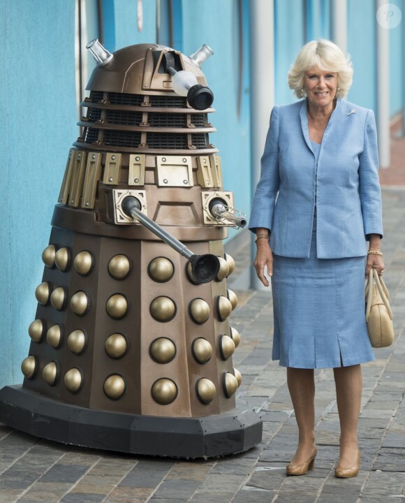 Le prince Charles et Camilla Parker Bowles visitent les studios de la série Doctor Who à Cardiff, le 3 juillet 2013. Ils ont rencontré les acteurs de la série Jenna-Lousie Coleman et Matt Smith. Elle prend ici la pose au côté d'un robot de la série.
