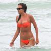 Irina Shayk, superbe dans son bikini orange Beach Bunny, se baigne avec un ami. Miami, le 21 juillet 2013.