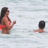 Irina Shayk, superbe dans son bikini orange Beach Bunny, se baigne avec un ami. Miami, le 21 juillet 2013.