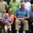  L'ex-président George H. W. Bush prend la pose avec Patrick (2 ans), fils de l'un de ses gardes du corps atteint d'une leucémie. En signe de solidarité, il s'est rasé la tête, comme une vingtaine d'agents de son service de sécurité, le 24 juillet 2013 à Kennebunkport. 
