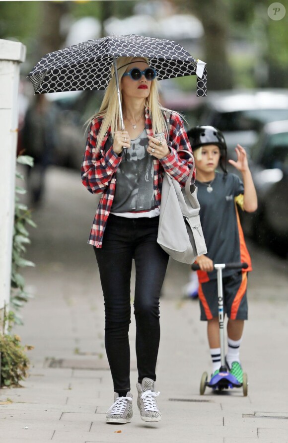 Gwen Stefani et ses fils Kingston et Zuma en trotinettes se promènent à Londres. Le 28 juillet 2013.