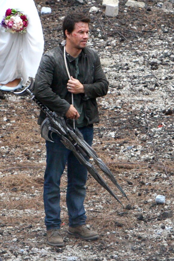 Mark Wahlberg avec une arme sur le tournage de Transformers 4 à Detroit, le 31 juillet 2014.