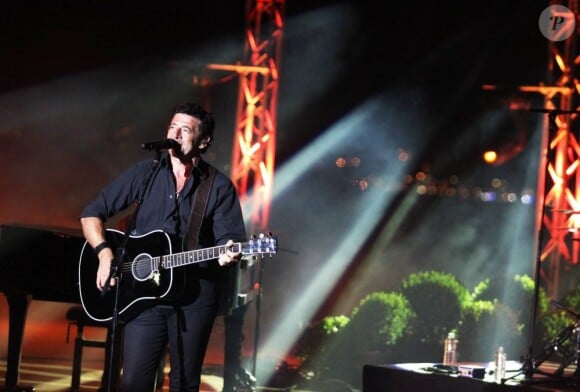 Au loin, les lueurs de la baie... Patrick Bruel en concert exceptionnel à la Citadelle de Saint-Tropez, le 15 août 2013, pour l'anniversaire du débarquement de Provence et la Libération.