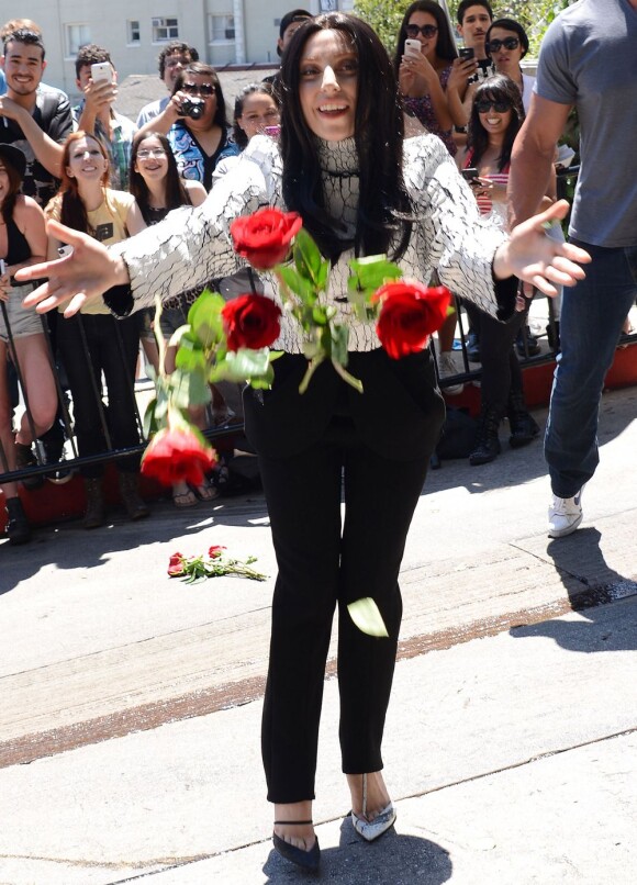 Lady Gaga jette des roses aux fans et photographes qui l'attendent devant le Chateau Marmont. West Hollywood, le 17 août 2013.
