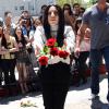 Lady Gaga jette des roses aux fans et photographes qui l'attendent devant le Chateau Marmont. West Hollywood, le 17 août 2013.