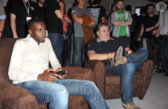 Blaise Matuidi du PSG et Pierre Ménès à la soirée de lancement de FIFA 14, organisée à la Gaîté Lyrique, à Paris, le 23 septembre 2013. La simulation de foot d'EA Sports sort le 26 septembre.
