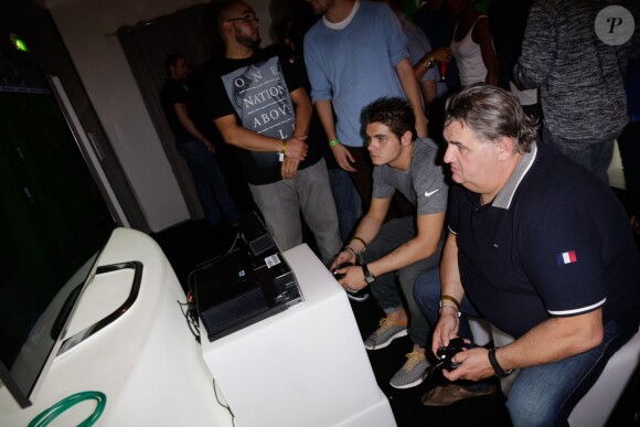 Pierre Ménès et son fils Axel en compétition à la soirée de lancement de FIFA 14, organisée à la Gaîté Lyrique, à Paris, le 23 septembre 2013. La simulation de foot d'EA Sports sort le 26 septembre.