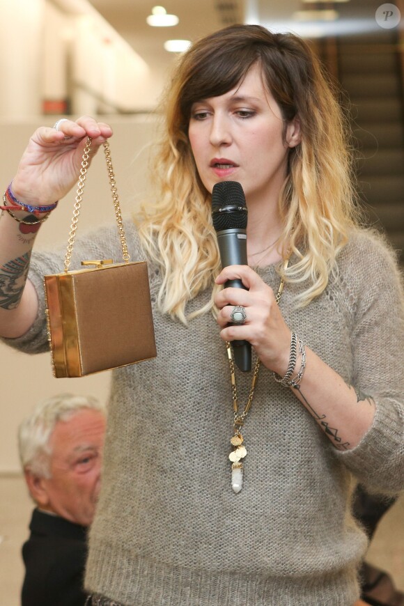 Daphné Burki fait la présentation d'un sac offert par Roselyne Bachelot à l'occasion de la vente aux enchères "Les femmes donnent aux femmes" au profit de l'Institut Curie à l'hôtel des ventes Drouot. Paris, le 22 octobre 2013.
