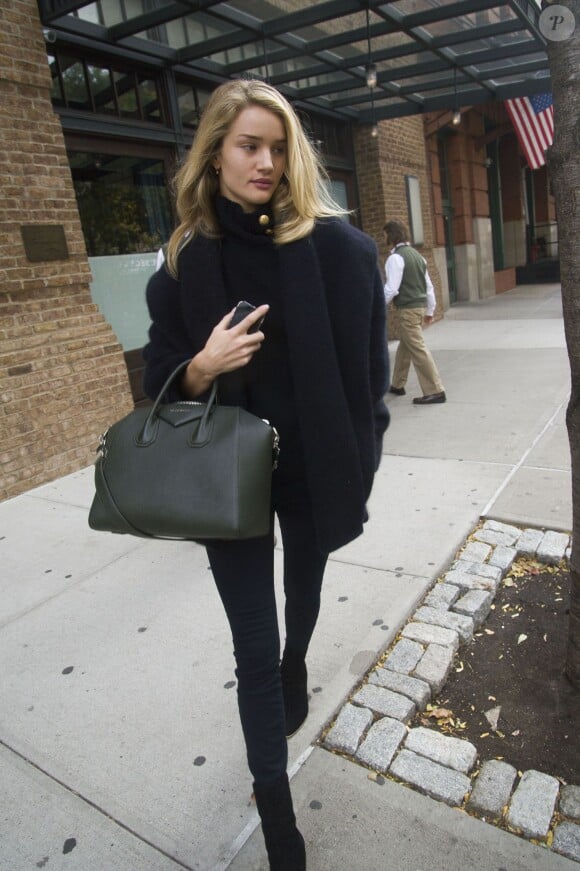 Rosie Huntington-Whiteley surprise dans le quartier de SoHo à New York, porte une veste et un pull Balmain, un sac Givenchy (modèle Antigona), un jean slim et des bottines noires. Le 6 novembre 2013.