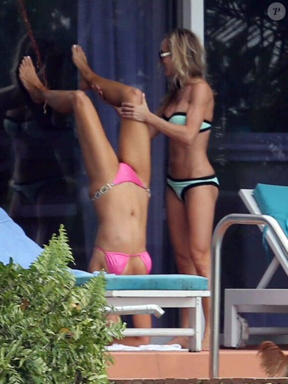 Joanna Krupa, sexy en bikini rose, fait preuve d'agilité devant une amie également sexy. Miami, le 10 novembre 2013.