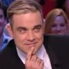 Antoine de Caunes montre ses fesses au chanteur Robbie Williams dans "Le grand journal de Canal +", mardi 26 novembre 2013.