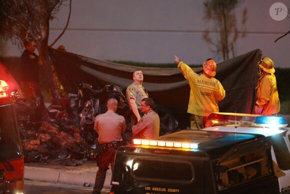 Les autorités intervenant et examinant la scène de l'accident fatal à l'acteur Paul Walker, star de Fast and Furious, tué à 40 ans dans le crash d'une Porsche GT dont il était le passager, le 30 novembre 2013 à Santa Clarita (nord de Los Angeles).