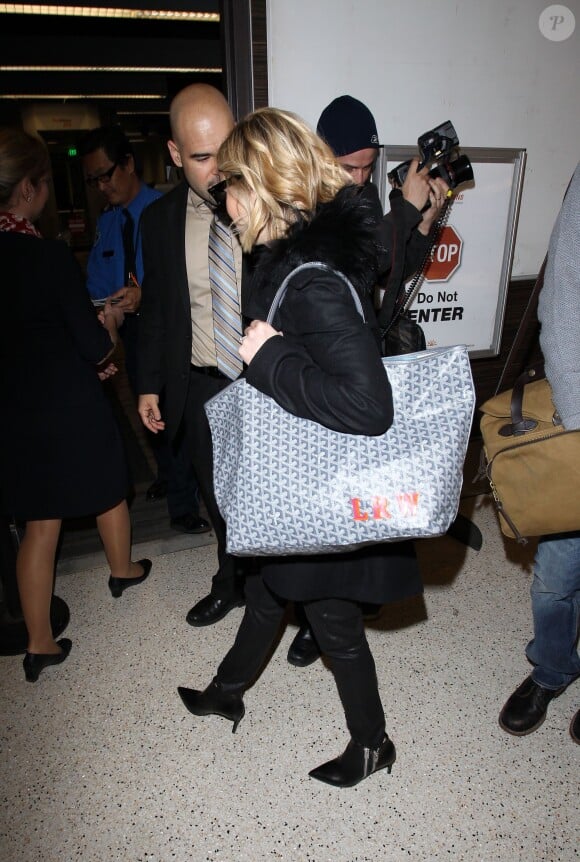 Reese Witherspoon et son mari Jim Toth à l'aéroport de Los Angeles, d'où ils décolleront à destination de Paris. Le 6 décembre 2013.