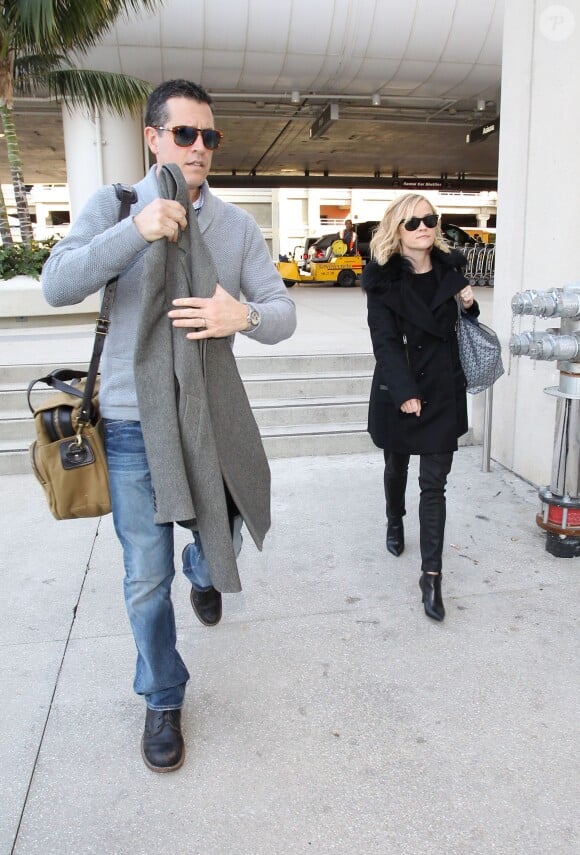 Reese Witherspoon et son mari Jim Toth à l'aéroport de Los Angeles, d'où ils décolleront à destination de Paris. Le 6 décembre 2013.