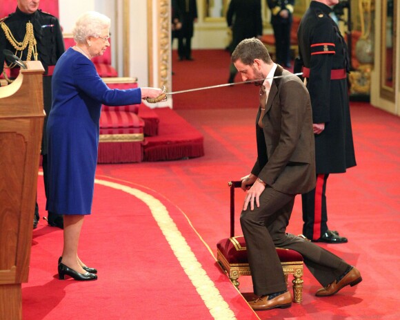 Bradley Wiggins anobli par la reine Elizabeth II au palais de Buckingham à Londres, le 10 décembre 2013