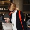 Gwyneth Paltrow, maman chic avec ses enfants Apple et Moses à l'aeroport de Los Angeles, accessoire sa tenue preppy d'un sac à dos Balenciaga (modèle Traveller S). Le 28 décembre 2013.