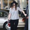 Kylie Jenner à l'aéroport de Los Angeles, porte un t-shirt rayé Theory, un pantalon en velours, un sac Chanel et des bottines Balenciaga. Le 27 décembre 2013.