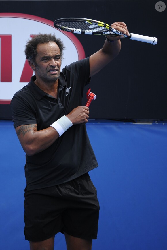 Yannick Noah a très chaud et s'octroie une pause fraîcheur lors du tournoi des légendes au Melbourne Park de Melbourne, le 20 janvier 2014 en marge de l'Open d'Australie