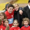 La princesse Charlene de Monaco au milieu des enfants lors du 4e Challenge Sainte-Dévote de Rugby au Stade Louis II de Monaco, le 1er février 2014