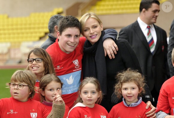 La princesse Charlene de Monaco au milieu des enfants lors du 4e Challenge Sainte-Dévote de Rugby au Stade Louis II de Monaco, le 1er février 2014