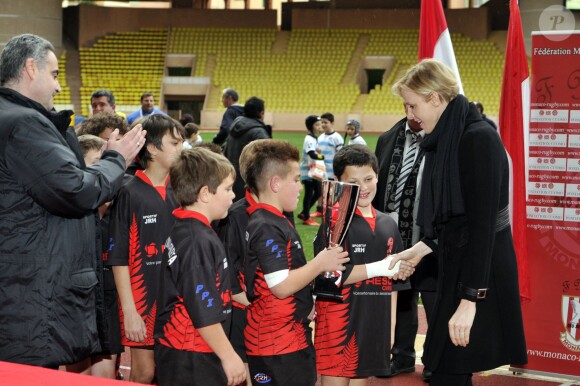 La princesse Charlene de Monaco remet à l'équipe de Lucciana le trophée lors du 4e Challenge Sainte-Dévote de Rugby au Stade Louis II de Monaco, le 1er février 2014