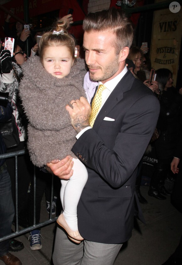 Harper blottie dans les bras de son papa David Beckham lors d'une virée au restaurant Balthazar après le défilé de Victoria un peu plus tôt dans la journée à New York. 9 février 2014