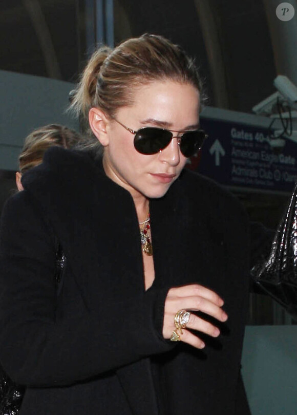Les jumelles Mary-Kate et Ashley Olsen arrivent à l'aéroport de Los Angeles, le 14 novembre 2013.