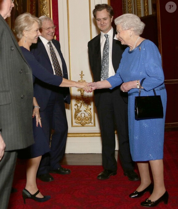 Helen Mirren et Elizabeth II se saluent sous l'oeil de Sir David Attenborough lors de la réception organisée le 17 février 2014 à Buckingham Palace pour célébrer les soixante ans du patronage de la Royal Academy of Dramatic Art par la reine Elizabeth II.