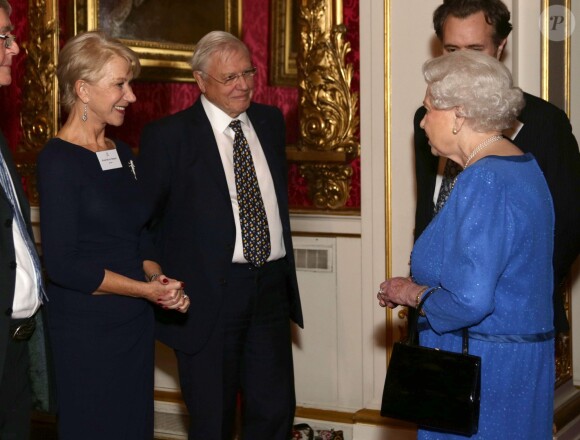 Elizabeth II et Dame Helen Mirren se rencontrent sous l'oeil de Sir David Attenborough lors de la réception organisée le 17 février 2014 à Buckingham Palace pour célébrer les soixante ans du patronage de la Royal Academy of Dramatic Art par la reine Elizabeth II.