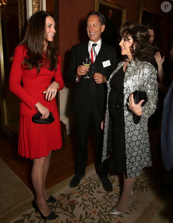 La duchesse Catherine de Cambridge rencontrant Richard E Grant et Joan Collins lors de la réception organisée le 17 février 2014 à Buckingham Palace pour célébrer les soixante ans du patronage de la Royal Academy of Dramatic Art par la reine Elizabeth II.