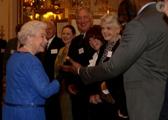 La reine Elizabeth II salue ses invités Lenny Henry, Steve McQueen, Dame Angela Lansbury, Lynda La Plante et Alan Rickman, lors de la réception organisée le 17 février 2014 à Buckingham Palace pour célébrer les soixante ans du patronage de la Royal Academy of Dramatic Art par la reine Elizabeth II.