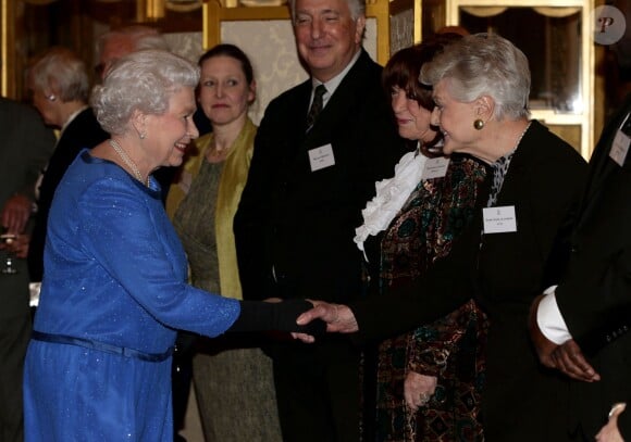 La reine Elizabeth II salue Dame Angela Lansbury lors de la réception organisée le 17 février 2014 à Buckingham Palace pour célébrer les soixante ans du patronage de la Royal Academy of Dramatic Art par la reine Elizabeth II.