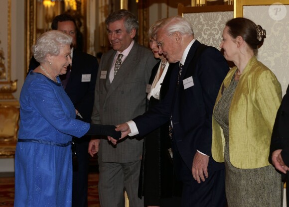 La reine Elizabeth II salue Sir David Attenborough lors de la réception organisée le 17 février 2014 à Buckingham Palace pour célébrer les soixante ans du patronage de la Royal Academy of Dramatic Art par la reine Elizabeth II.