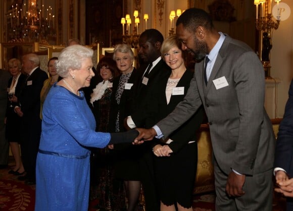 Elizabeth II saluant Lenny Henry lors de la réception organisée le 17 février 2014 à Buckingham Palace pour célébrer les soixante ans du patronage de la Royal Academy of Dramatic Art par la reine Elizabeth II.