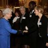 Elizabeth II saluant Jane Horrocks lors de la réception organisée le 17 février 2014 à Buckingham Palace pour célébrer les soixante ans du patronage de la Royal Academy of Dramatic Art par la reine Elizabeth II.