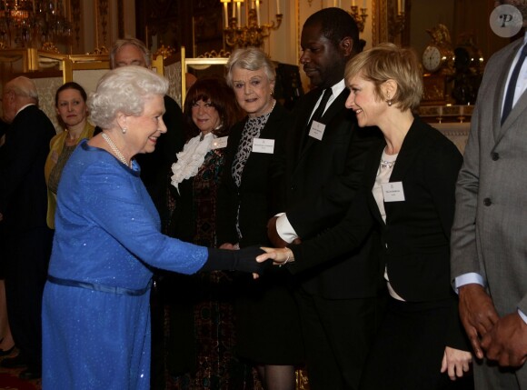 Elizabeth II saluant Jane Horrocks lors de la réception organisée le 17 février 2014 à Buckingham Palace pour célébrer les soixante ans du patronage de la Royal Academy of Dramatic Art par la reine Elizabeth II.