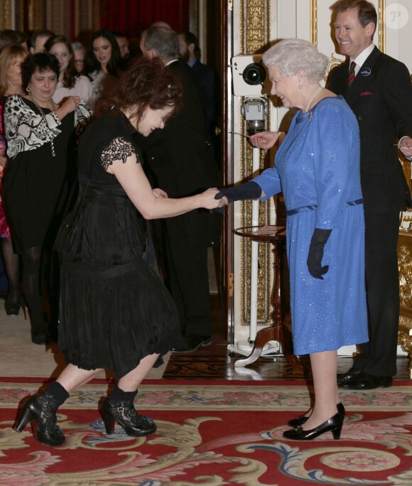 Helena Bonham Carter fait la révérence devant Elizabeth II lors de la réception organisée le 17 février 2014 à Buckingham Palace pour célébrer les soixante ans du patronage de la Royal Academy of Dramatic Art par la reine Elizabeth II.