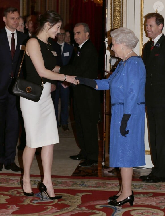 Elizabeth II salue Gemma Arterton lors de la réception organisée le 17 février 2014 à Buckingham Palace pour célébrer les soixante ans du patronage de la Royal Academy of Dramatic Art par la reine Elizabeth II.