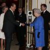 Elizabeth II salue Sir Roger Moore lors de la réception organisée le 17 février 2014 à Buckingham Palace pour célébrer les soixante ans du patronage de la Royal Academy of Dramatic Art par la reine Elizabeth II.