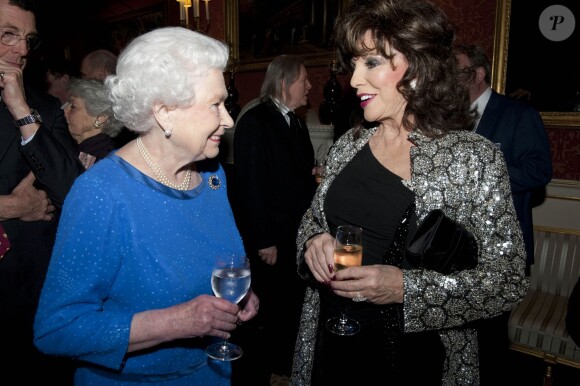 Elizabeth II et Joan Collins lors de la réception organisée le 17 février 2014 à Buckingham Palace pour célébrer les soixante ans du patronage de la Royal Academy of Dramatic Art par la reine Elizabeth II.