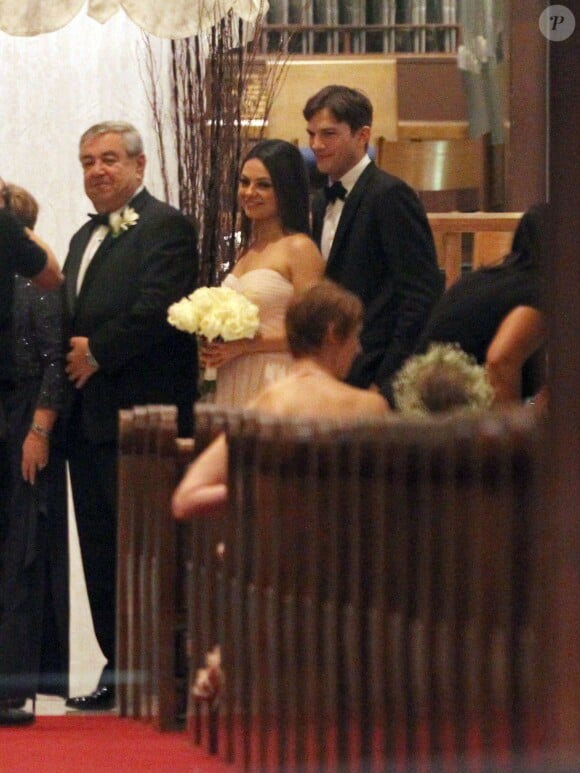 Mila Kunis entre son père, Mark Kunis et son petit-ami Ashton Kutcher le 7 décembre 2013 au mariage du frère de Mila en Floride