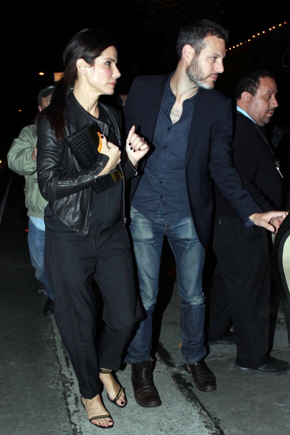 Sandra Bullock et un mystérieux inconnu très protecteur quittent Craig's à West Hollywood, Los Angeles, le 12 mars 2014.